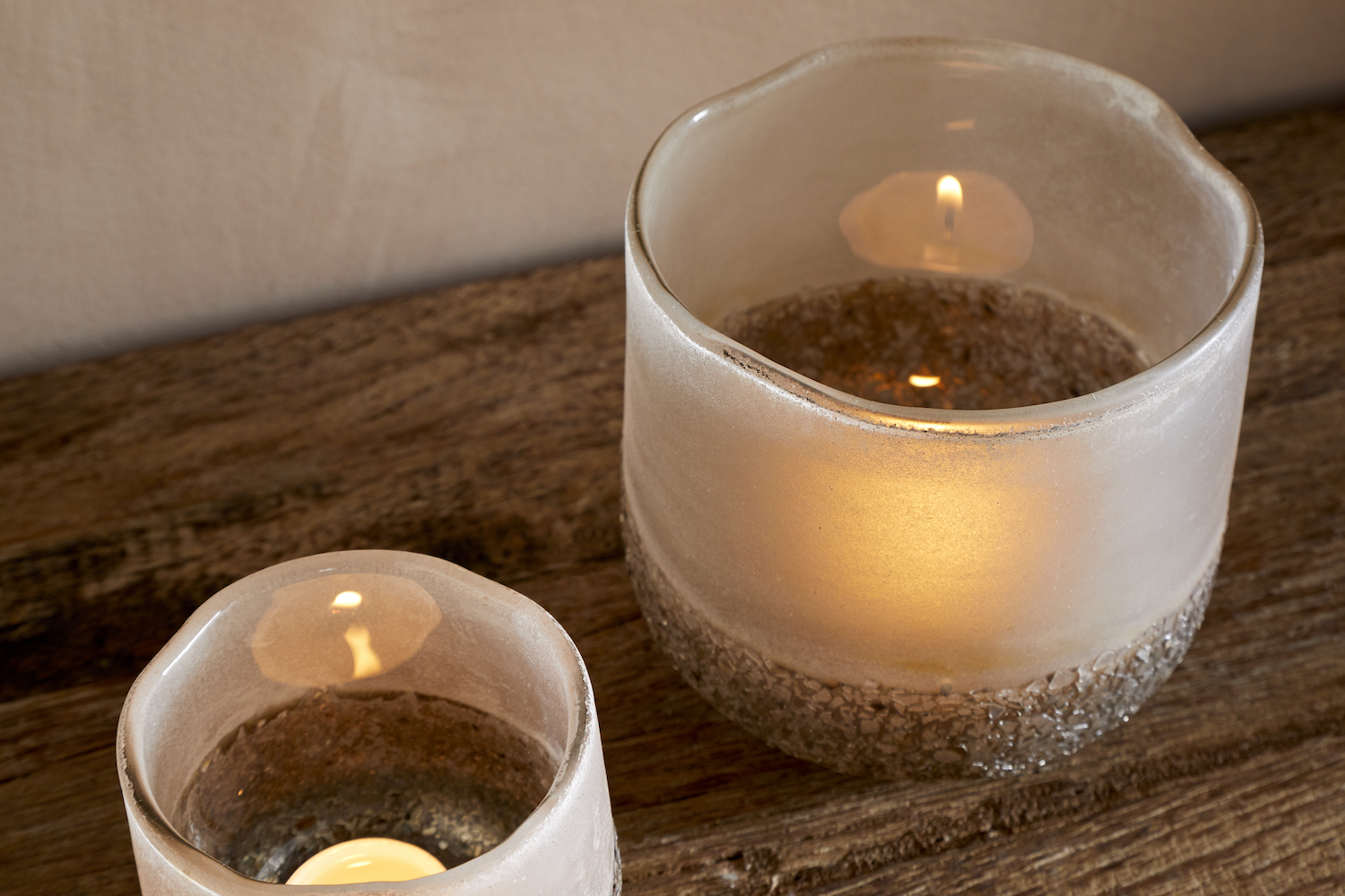 Close Up of Riyara Recycled Glass Tealight Holder in Silver Sparkle by Nkuku styled and lit for a warm atmospheric effect.