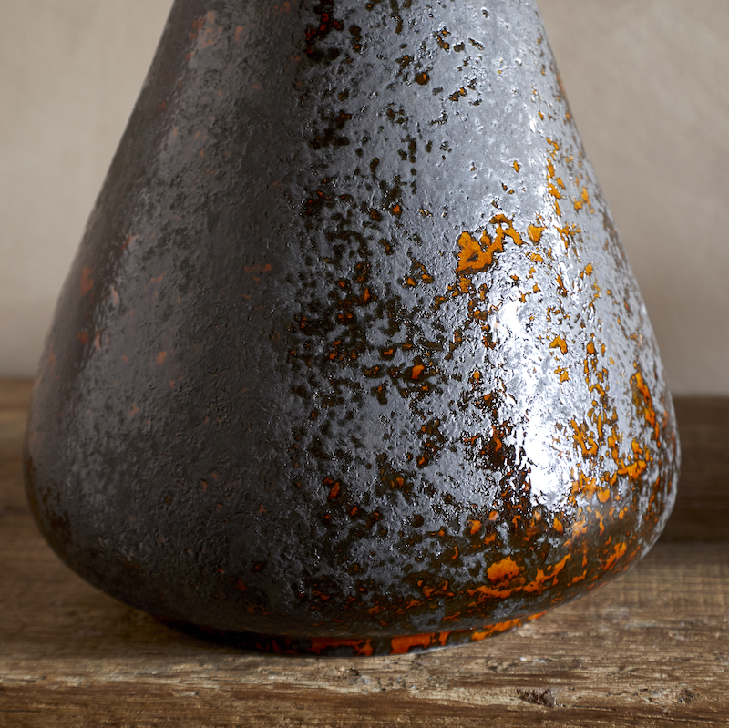 Brija Vase in Brown by Nkuku styled with flowers, closeup featuring a rich reactive glaze and softly textured finish.