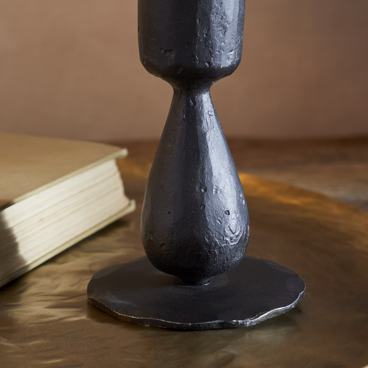 Close-up of the Suba Candle Holder in Black by Nkuku showing the hand-forged textured iron finish.