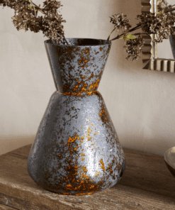 Brija Vase in Brown by Nkuku styled with flowers, featuring a rich reactive glaze and softly textured finish.