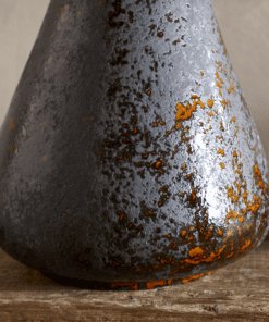 Brija Vase in Brown by Nkuku styled with flowers, closeup featuring a rich reactive glaze and softly textured finish.