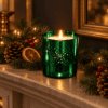 Christmas Spice Luxury Candle in emerald electroplated glass lit on a fireplace mantel with subtle Christmas greenery and warm seasonal decoration.