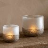 Riyara Recycled Glass Tealight Holder in Silver Sparkle by Nkuku styled and lit for a warm atmospheric effect.