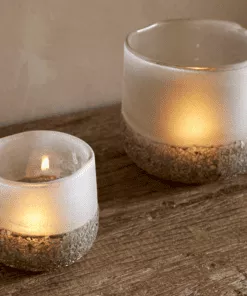 Riyara Recycled Glass Tealight Holder in Silver Sparkle by Nkuku styled and lit for a warm atmospheric effect.