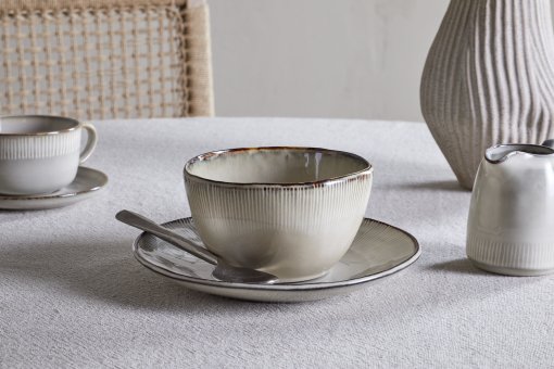 Nkuku Malia Breakfast Bowl in Cream, featuring a softly curved shape, fine vertical ribbed detailing, a warm cream glaze and a contrasting hand-finished brown rim.